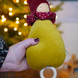 A close up of the Nanchen Little Red Riding Hood Lullaby Music Doll in an adult's hand. A musical Waldorf doll, made from organic cotton and sheep's wool. 