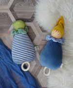 Two Nanchen Lullaby Music Dolls. Musical Waldorf dollS, made from organic cotton and sheep's wool. The blue dream king and frog lullaby dolls have been placed on a rug on a wooden floor. 