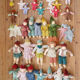 Large selection of Nanchen Natur handmade organic Waldorf dolls and comforters placed on a wooden floor in the Babipur playroom.
