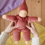 Nanchen Natur Nani Waldorf doll in cedar pink in an adult's hands in the Babipur playroom. 