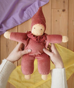 Nanchen Natur Nani Waldorf doll in cedar pink in an adult's hands in the Babipur playroom. 