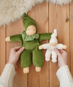 Nanchen Natur Waldorf Nani doll in forest green and a natural pimpel dolls in an adult's hands in the Babipur playroom. 