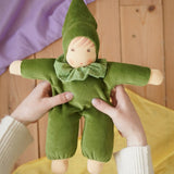 Nanchen Natur Waldorf Nani doll in forest green in an adult's hands in the Babipur playroom. 