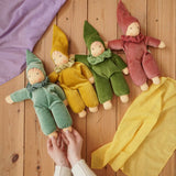 Four Nanchen Natur handmade Nani Waldorf dolls in mint, goldm forest green and cedar pink placed on a wooden floor in the Babipur playroom. 
