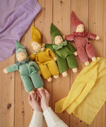 Four Nanchen Natur handmade Nani Waldorf dolls in mint, goldm forest green and cedar pink placed on a wooden floor in the Babipur playroom. 