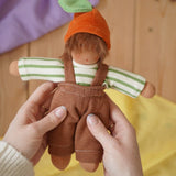 Nanchen Otto Orange child Waldorf doll in an adult's hand in the Babipur playroom.