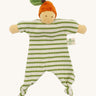 Front view of the Nanchen Orange Baby Comforter, a handcrafted doll with a natural-toned face and an orange velour fruit-inspired hat topped with a green leaf. The body is made of green and white striped organic cotton terry with knotted feet and extended arms, and includes a "Nanchen Natur" brand tag.