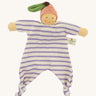 Front view of the Nanchen Peach Baby Comforter, a handmade doll with a soft, peach-colored face and pink velour fruit-shaped hat with a green leaf and brown stem. The doll has a lilac and white striped organic cotton terry body with knotted feet and outstretched arms, and a fabric label reading "Nanchen Natur" on the side.
