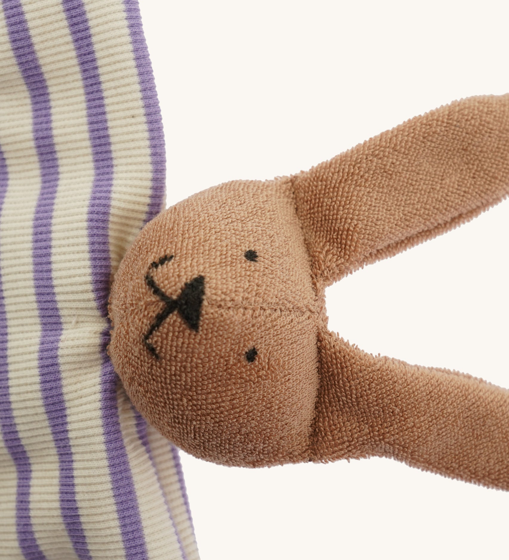 A closeup of The Nanchen organic rabbit baby comforter, with cute stitched bunny features