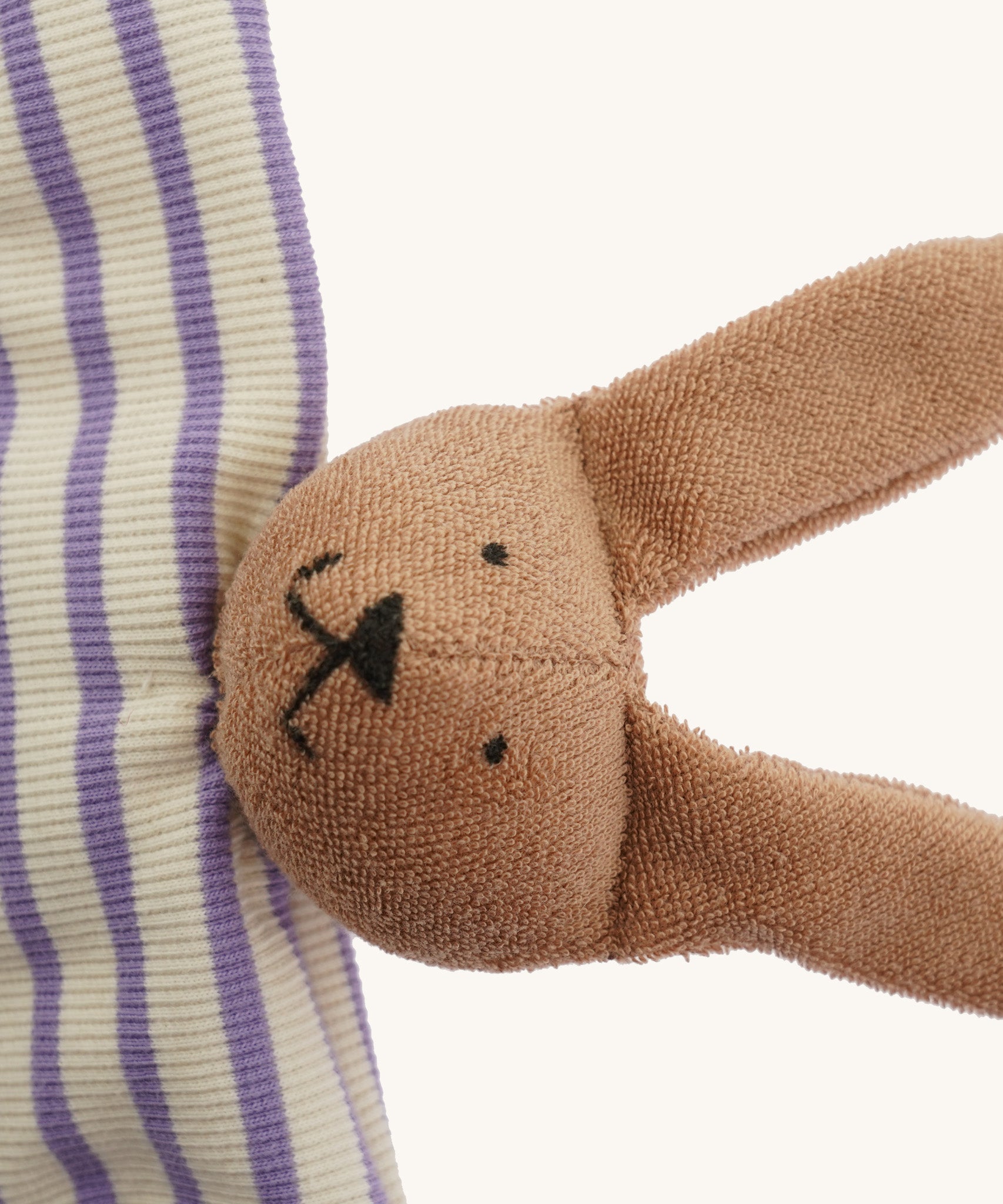 A closeup of The Nanchen organic rabbit baby comforter, with cute stitched bunny features