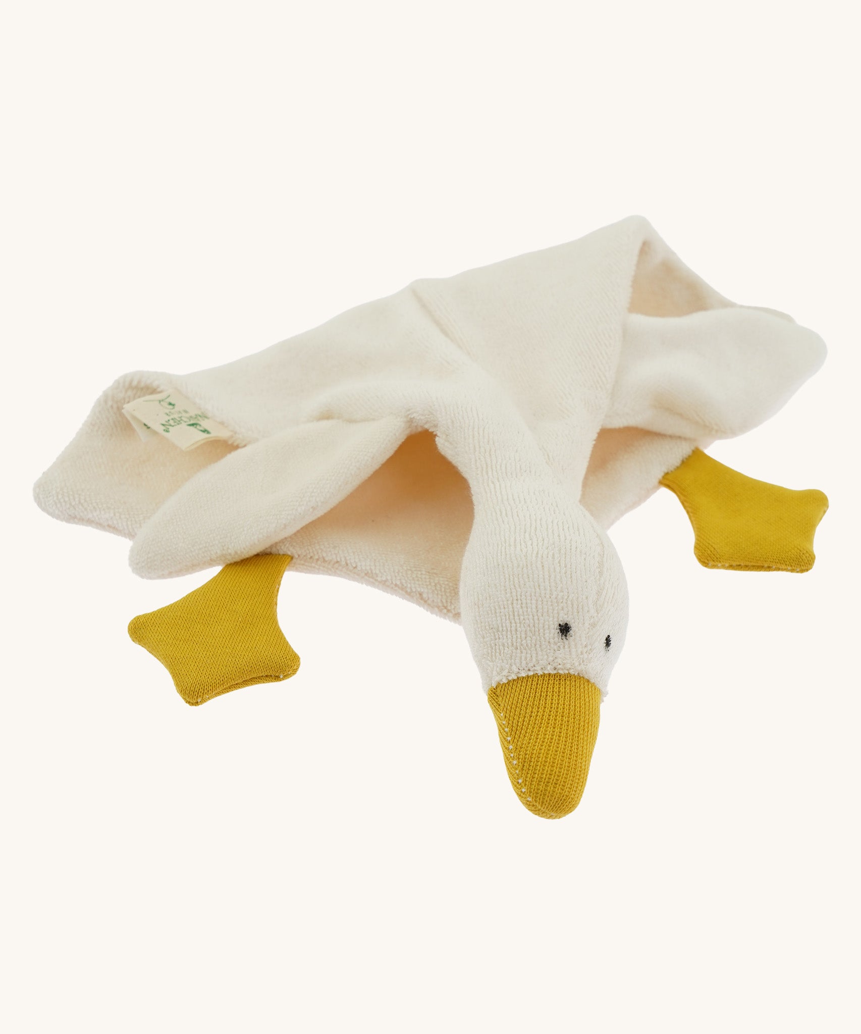 Side view of the Nanchen White Goose Comforter lying down. The doll’s soft terry fabric body drapes naturally, highlighting its cuddly, blanket-like shape and plush wool-stuffed head.