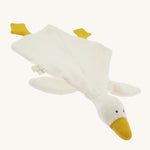 Angled front view of the Nanchen White Goose Baby Comforter laid flat. The soft cream-colored blanket body spreads out with attached yellow feet and a raised plush goose head with a gentle, minimalist expression.