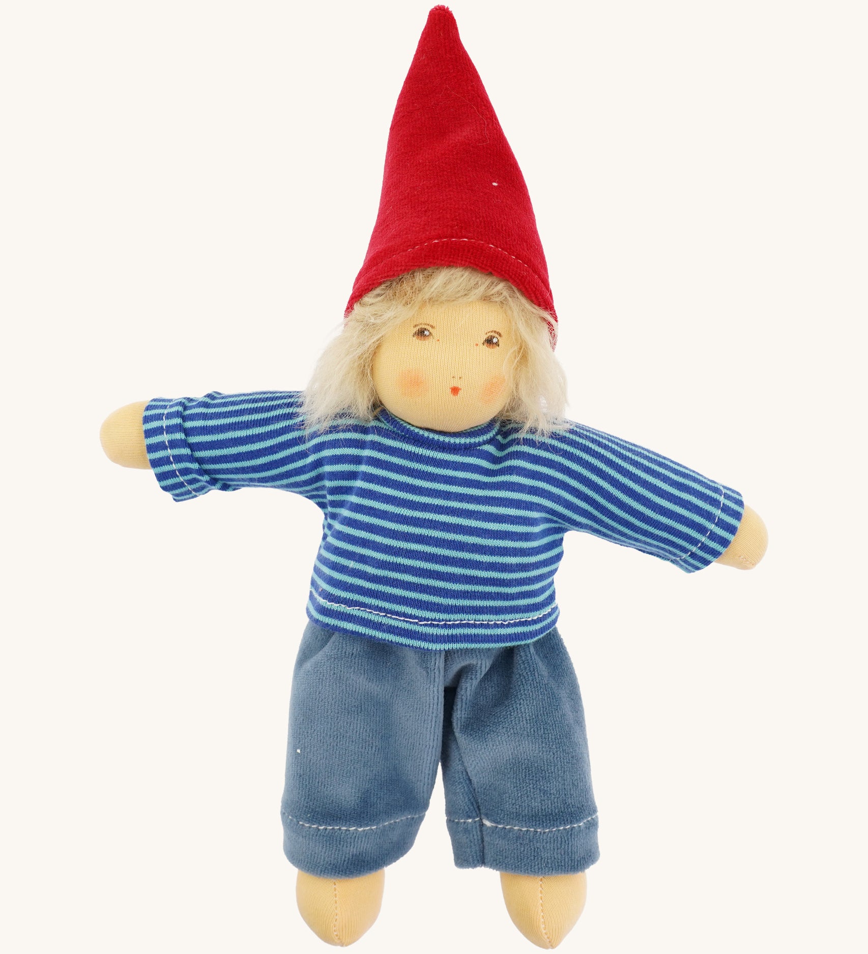 Front-facing image of the Nanchen Frederik handmade Waldorf doll fully dressed in its gnome-inspired outfit, wearing a red pointed hat, blue striped top, and blue trousers. The doll has soft blond mohair hair and a natural peach-toned cotton body.
