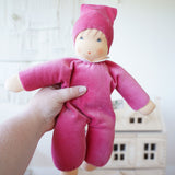 A Nanchen pink Nani Waldorf Doll being held up in an adult's hand. These organic handcrafted dolls are part of a wide selection of dolls and soft toys here at Babipur. 