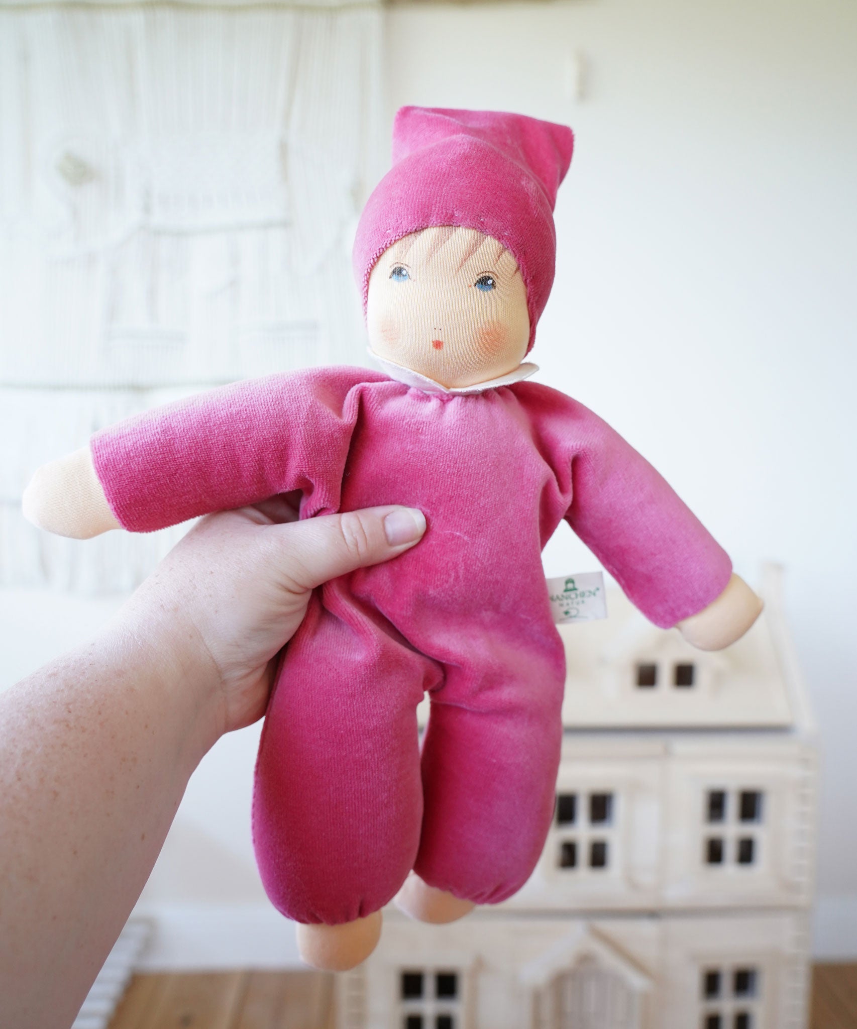 A Nanchen pink Nani Waldorf Doll being held up in an adult's hand. These organic handcrafted dolls are part of a wide selection of dolls and soft toys here at Babipur. 