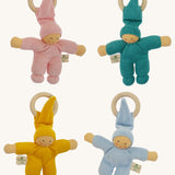 Four Nanchen Waldorf Pimpel Doll Baby Comforters arranged in a square. Each has a soft terry cotton body in pink, turquoise, yellow, or blue, a pointed hat, and an attached wooden teething ring. The dolls feature painted facial features and soft, knotted feet and hands.
