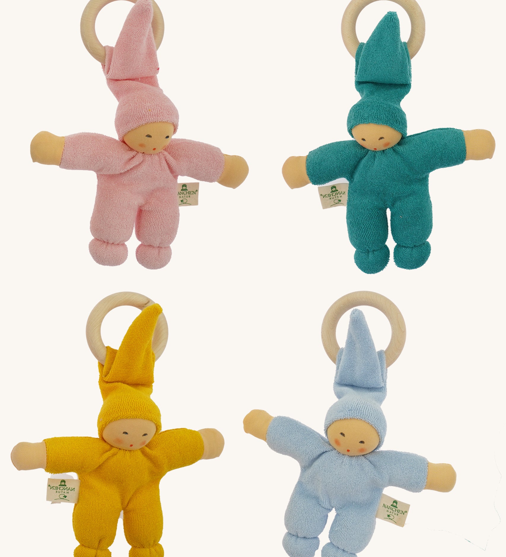 Four Nanchen Waldorf Pimpel Doll Baby Comforters arranged in a square. Each has a soft terry cotton body in pink, turquoise, yellow, or blue, a pointed hat, and an attached wooden teething ring. The dolls feature painted facial features and soft, knotted feet and hands.
