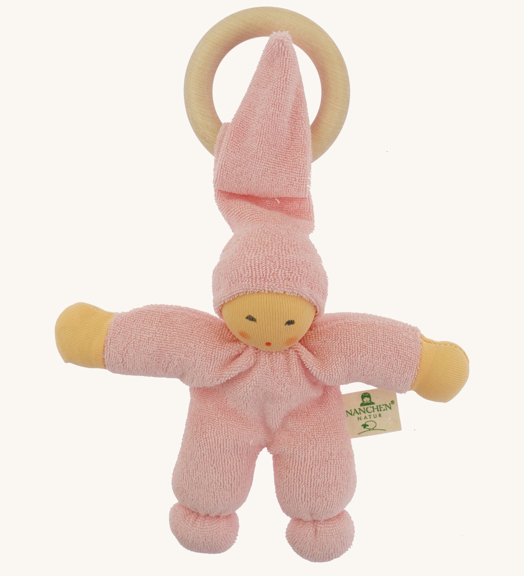 Front view of the Nanchen Pimpel Doll Baby Comforter in pink, with a pointed hat looped through a wooden teething ring. The doll has a natural-toned face with delicately painted features and soft yellow arms.