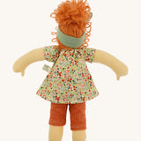 The back of The Nanchen 'Flore' organic Waldorf doll, with curly red hair, a floral top, orange trousers, and a green hair bow.