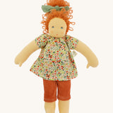 The Nanchen 'Flore' organic Waldorf doll, with curly red hair, a floral top, orange trousers, and a green hair bow.