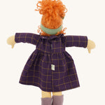 The back of the Nanchen 'Marlene' organic Waldorf doll, with curly red hair, a purple patterned dress, lilac shoes, and a green hair bow.