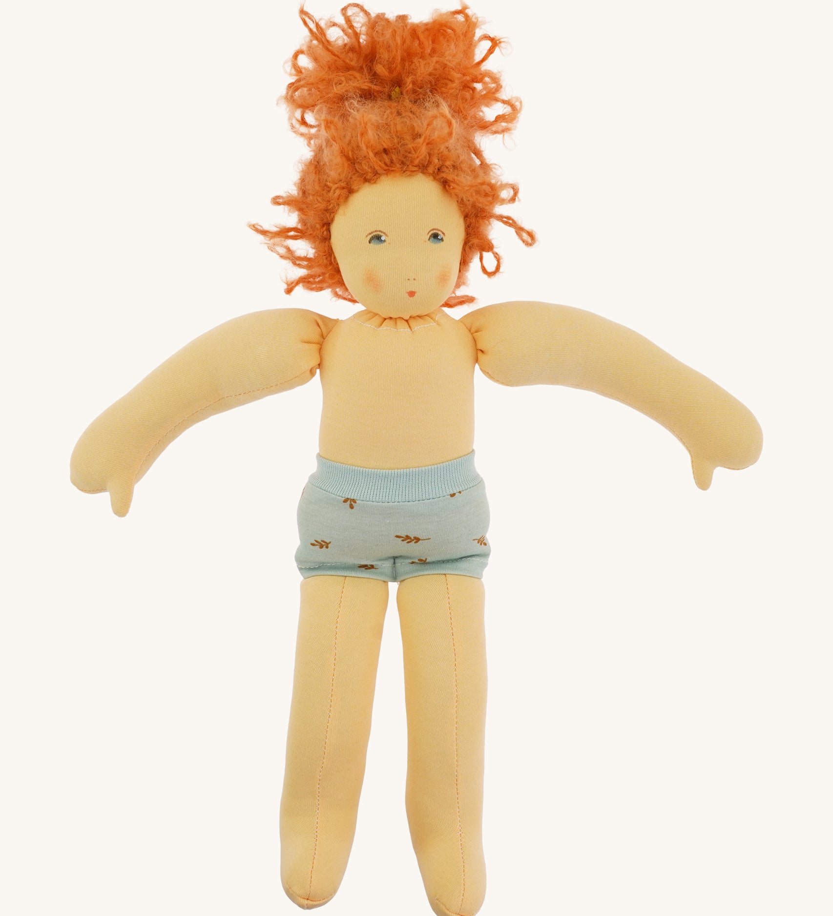 The Nanchen 'Marlene' organic Waldorf doll with curly red hair, with her clothes taken off and only wearing her blue underwear.