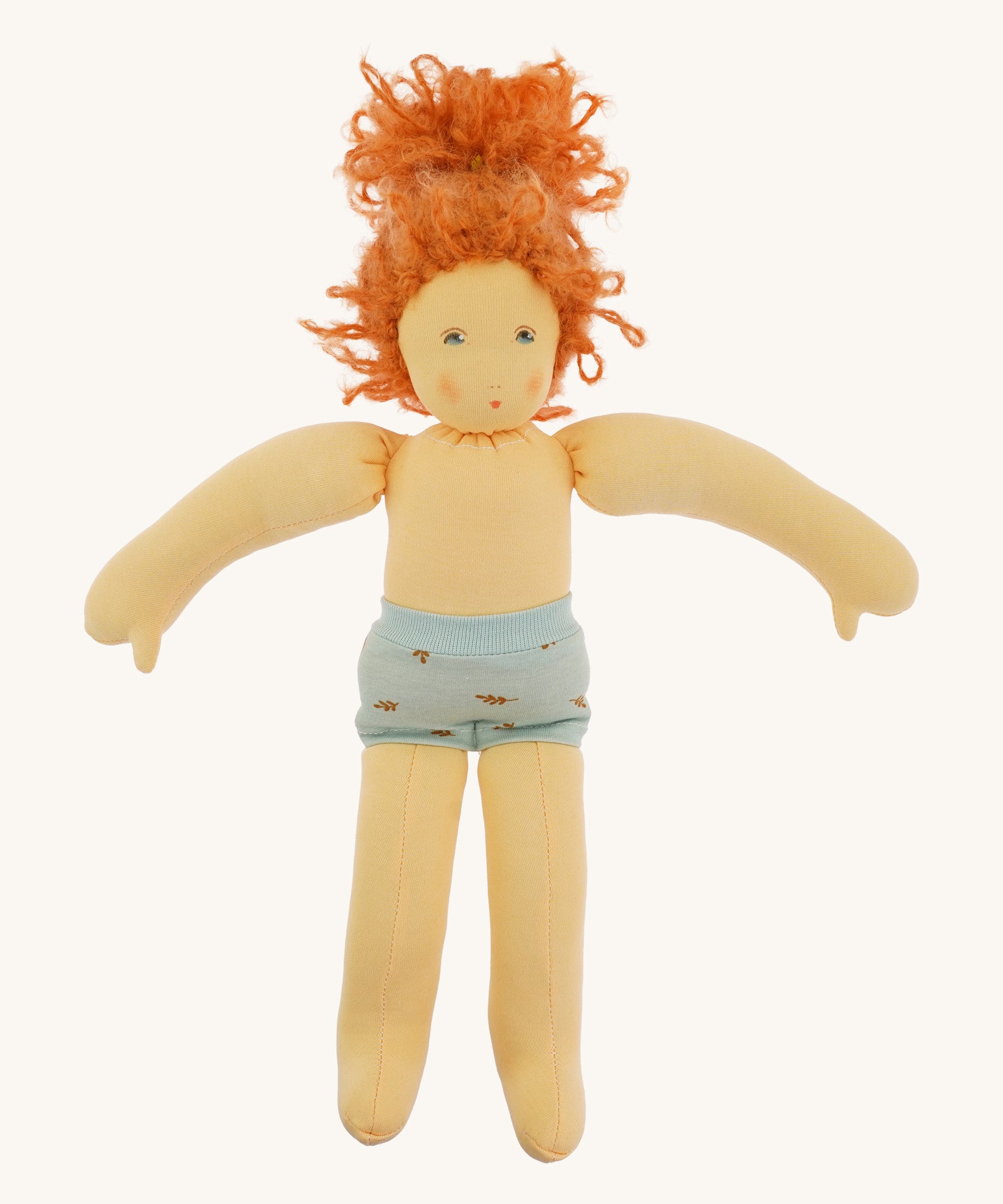 The Nanchen 'Marlene' organic Waldorf doll with curly red hair, with her clothes taken off and only wearing her blue underwear.