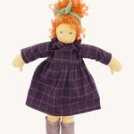 The Nanchen 'Marlene' organic Waldorf doll, with curly red hair, a purple patterned dress, lilac shoes, and a green hair bow.