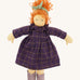 The Nanchen 'Marlene' organic Waldorf doll, with curly red hair, a purple patterned dress, lilac shoes, and a green hair bow.