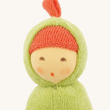 Close-up of the Nanchen Pea Pod Rattle Doll’s face, showing its delicately hand-painted features including closed eyes and a small mouth. The doll wears a red terry bonnet under a green hood with a small top knot.
