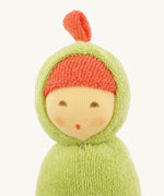 Close-up of the Nanchen Pea Pod Rattle Doll’s face, showing its delicately hand-painted features including closed eyes and a small mouth. The doll wears a red terry bonnet under a green hood with a small top knot.
