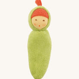 Front view of the Nanchen Pea Pod Rattle Doll, featuring a soft green organic cotton body shaped like a pea pod. The doll has a round hand-painted face with rosy cheeks and a red terry top knot, peeking from a hooded design.