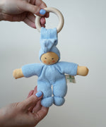 A light blue Nanchen Pimpel Waldorf Doll Ring Comforter toy being held in an adult's hands.