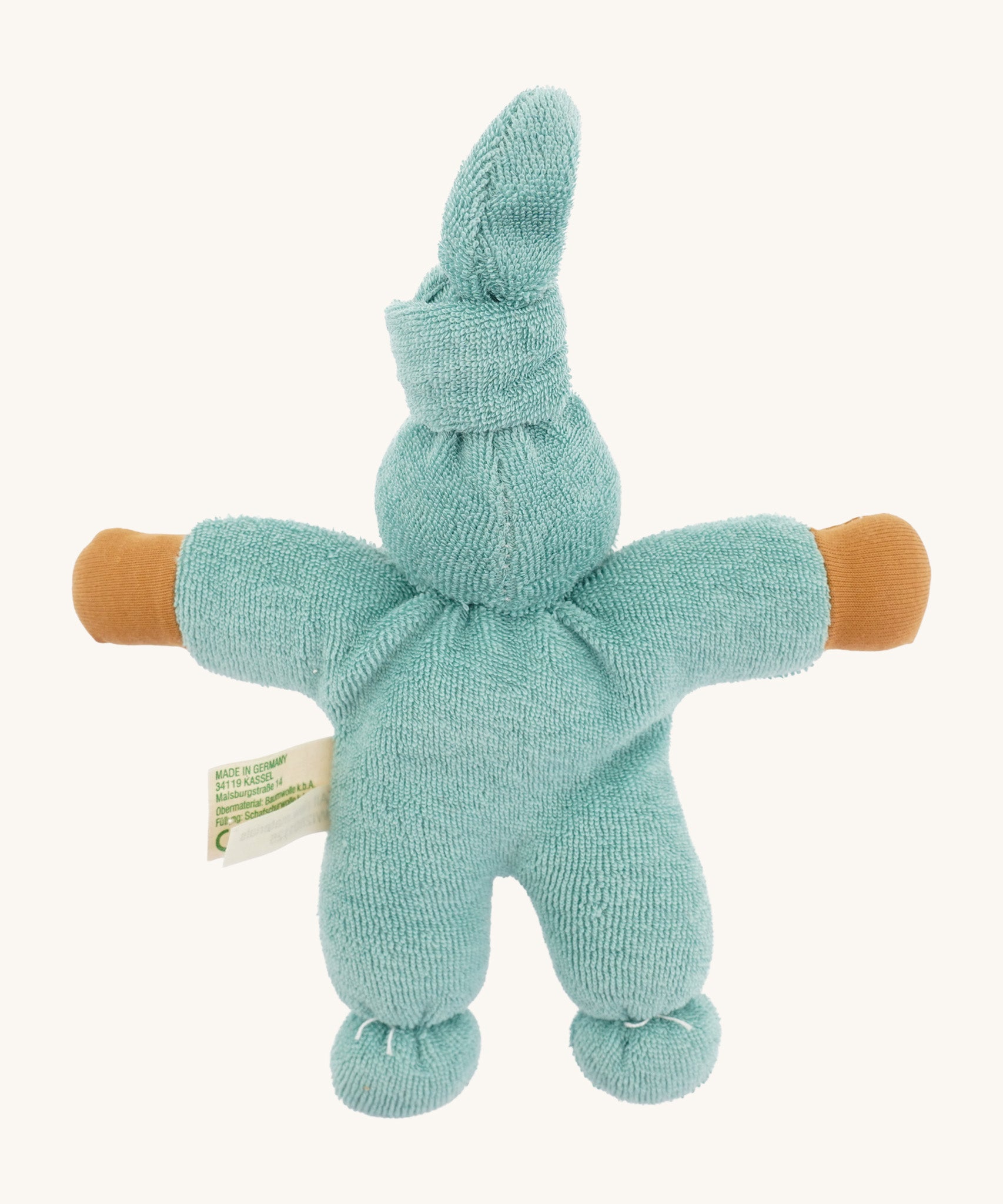 Back view of the Nanchen Pimpel Waldorf Doll in sage. The pointed hat is tied at the top, and the doll’s plush terry cotton body and arms are fully visible, along with a product tag at the side.
