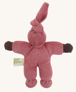 The back of the Nanchen Pimpel Waldorf Handcrafted Doll with a berry pink coloured outfit an matching knotted hat.