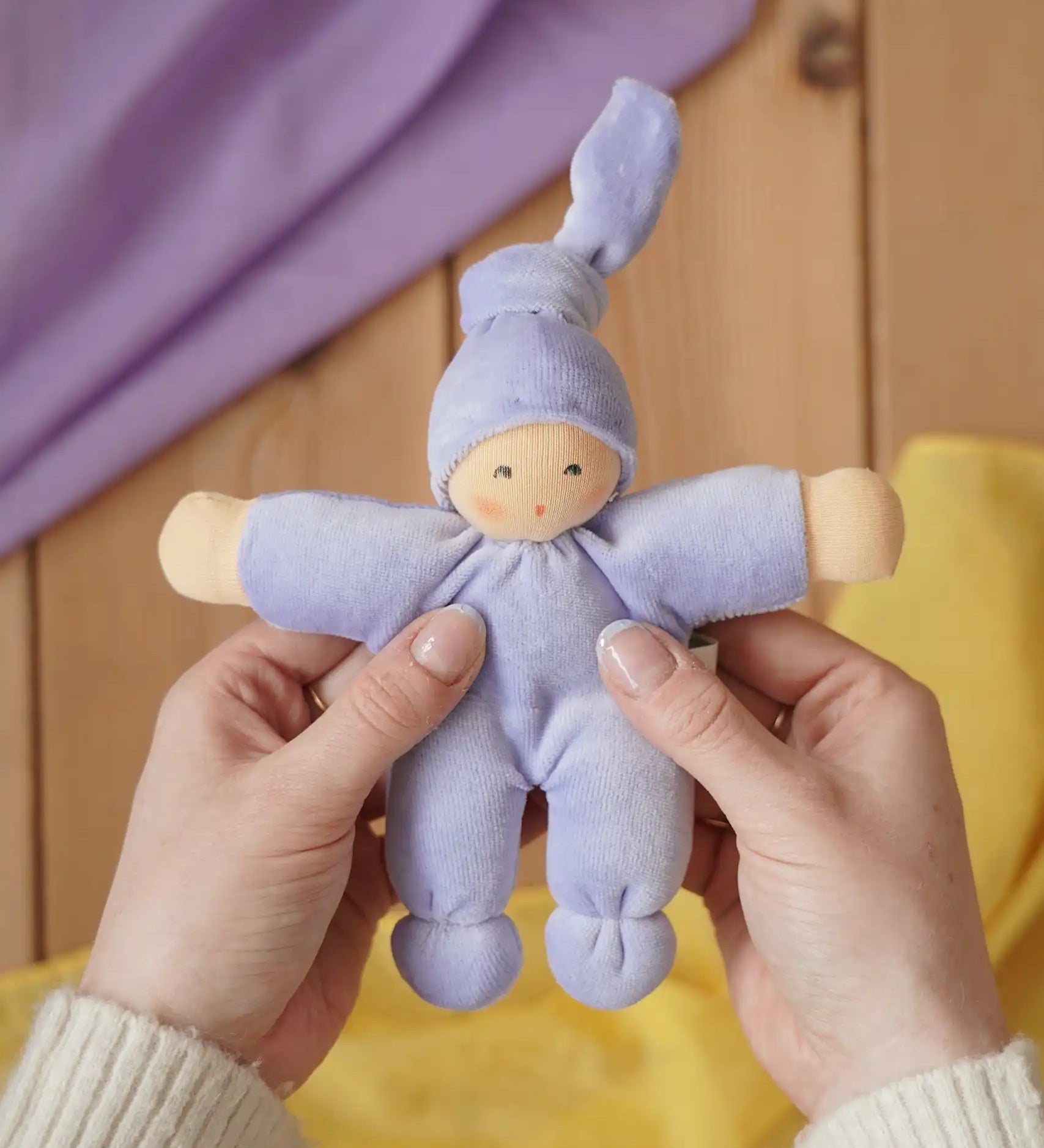 Nanchen Natur Pimpel Waldorf doll in lavender in an adult's hand in the Babipur playroom