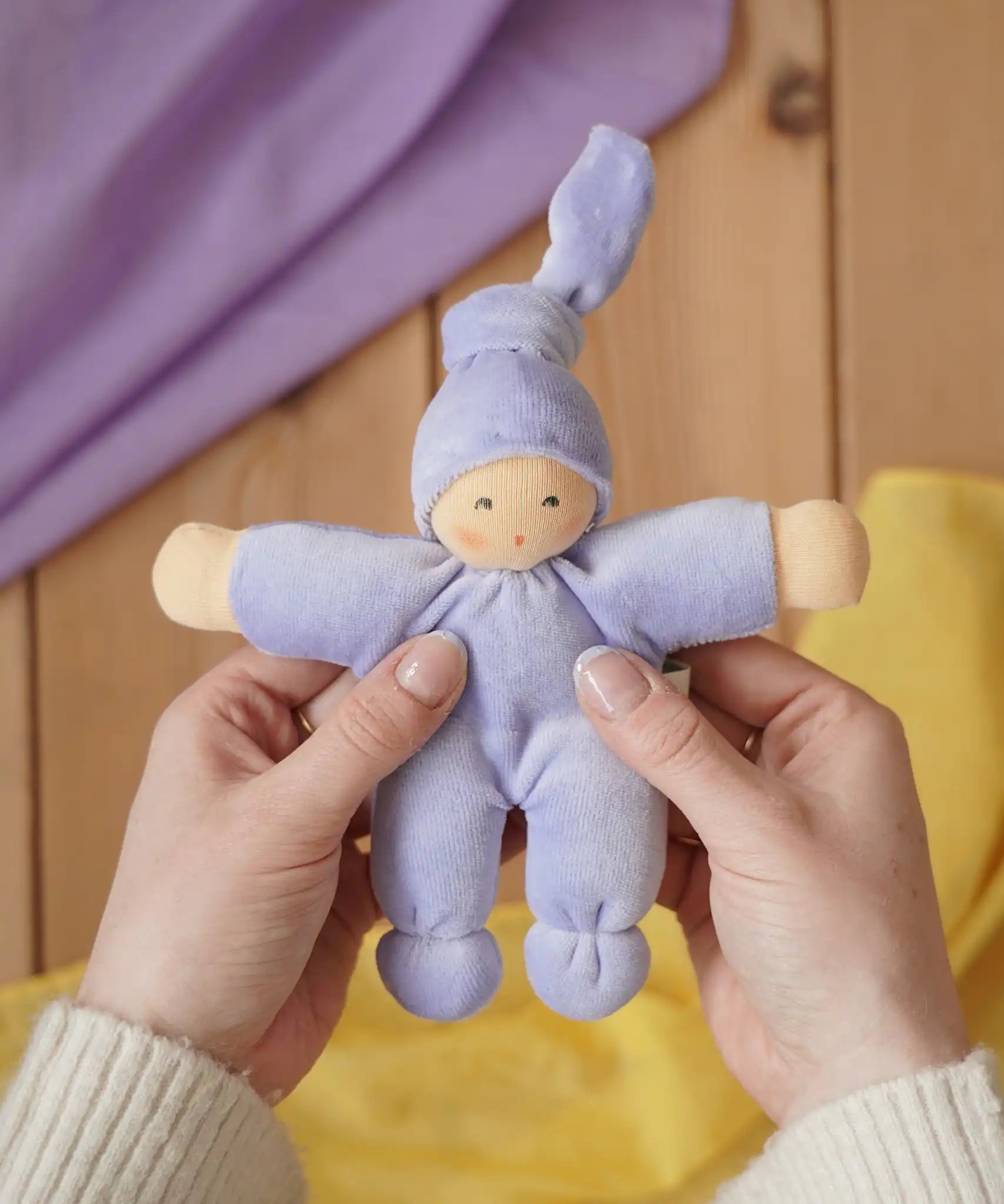 Nanchen Natur Pimpel Waldorf doll in lavender in an adult's hand in the Babipur playroom