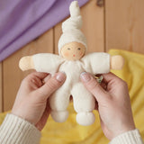 Nanchen Natur Pimpel Waldorf doll in natural in an adult's hands in the Babipur playroom. 