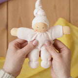 Nanchen Natur Pimpel Waldorf doll in pastel pink in an adult's hands in the Babipur playroom. 