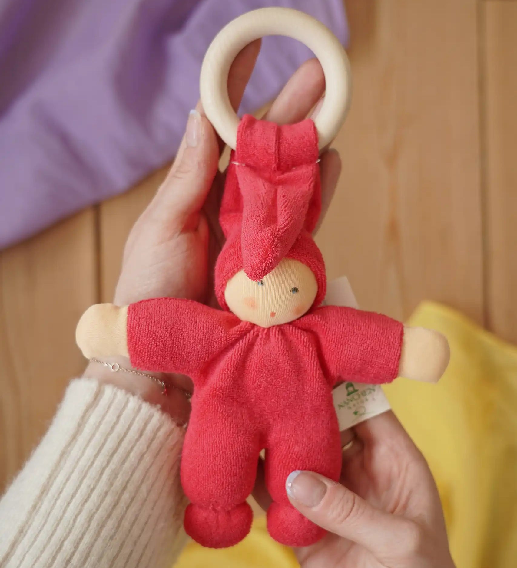 Cherry red Nanchen Pimpel Waldorf Doll Ring Comforter in an adult's hands. 
