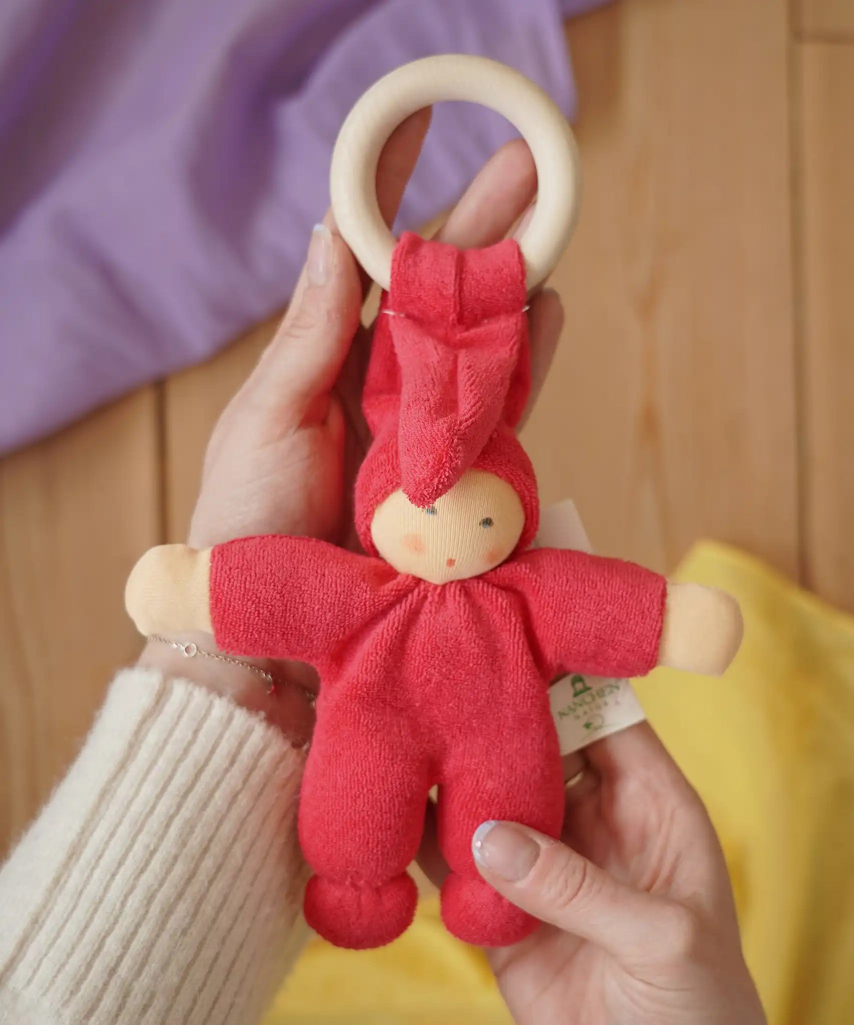 Cherry red Nanchen Pimpel Waldorf Doll Ring Comforter in an adult's hands. 