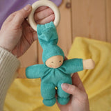 A turquoise coloured Nanchen Pimpel Waldorf Doll Ring Comforter in an adult's hands in the Babipur playroom. 