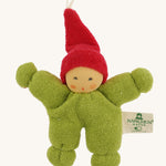 A little Nanchen gnome doll for the carry cot wearing a green onesie and a red hat on a cream background.