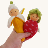 Nanchen banana and strawberry Baby Rattle Dolls in an adult's hand. 