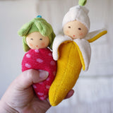 Nanchen banana and strawberry Baby Rattle Dolls in an adult's hand. 