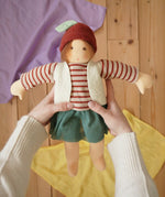 Nanchen Natur dress-up Waldorf doll chestnut child Karlotta in an adults hands in the Babipur playroom.