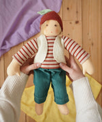 Nanchen Natur dress-up Waldorf doll chestnut child Paul in an adult's hands in the Babipur playroom.