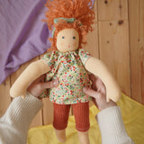 Nanchen Natur Flore Waldorf doll in an adult's hand in the Babipur playroom.