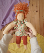 Nanchen Natur Flore Waldorf doll in an adult's hand in the Babipur playroom.