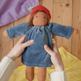 Nanchen Waldorf Doll Garden Child lene with apple hat in an adult's hand in the Babipur playroom. 
